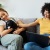 a couple of women sitting on a couch with a dog